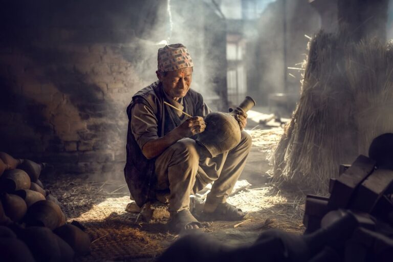 the old man is painting in a clay