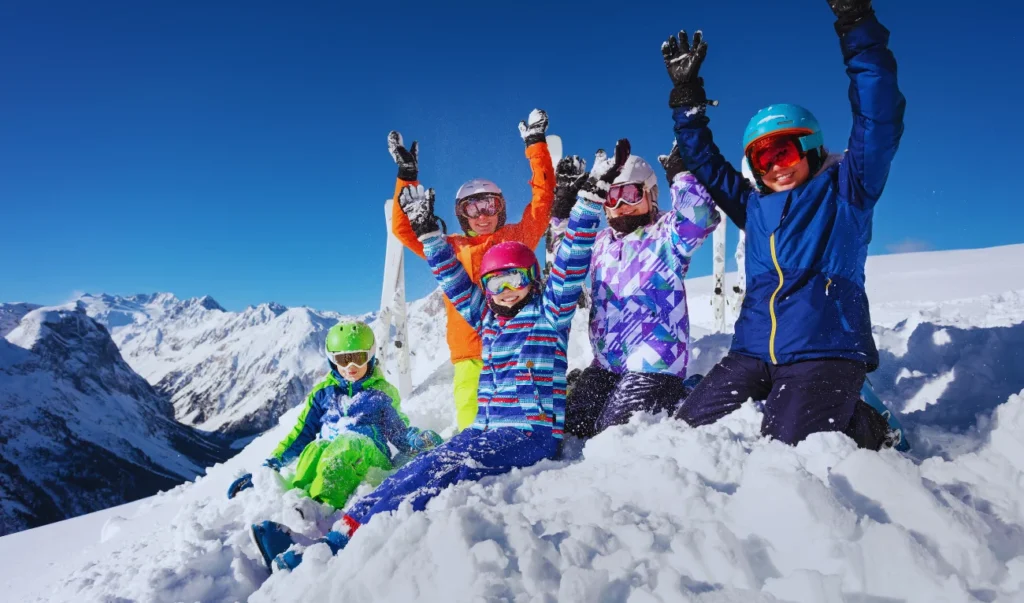 a group of skiers posing for a photo on top of a snowy mountain