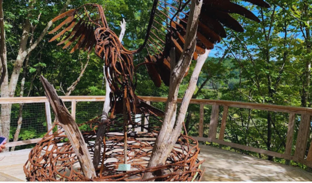 a metal sculpture of an eagle sitting on top of a nest